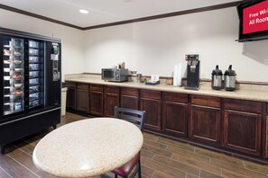A kitchenette with a microwave, coffee maker, and a refrigerator.