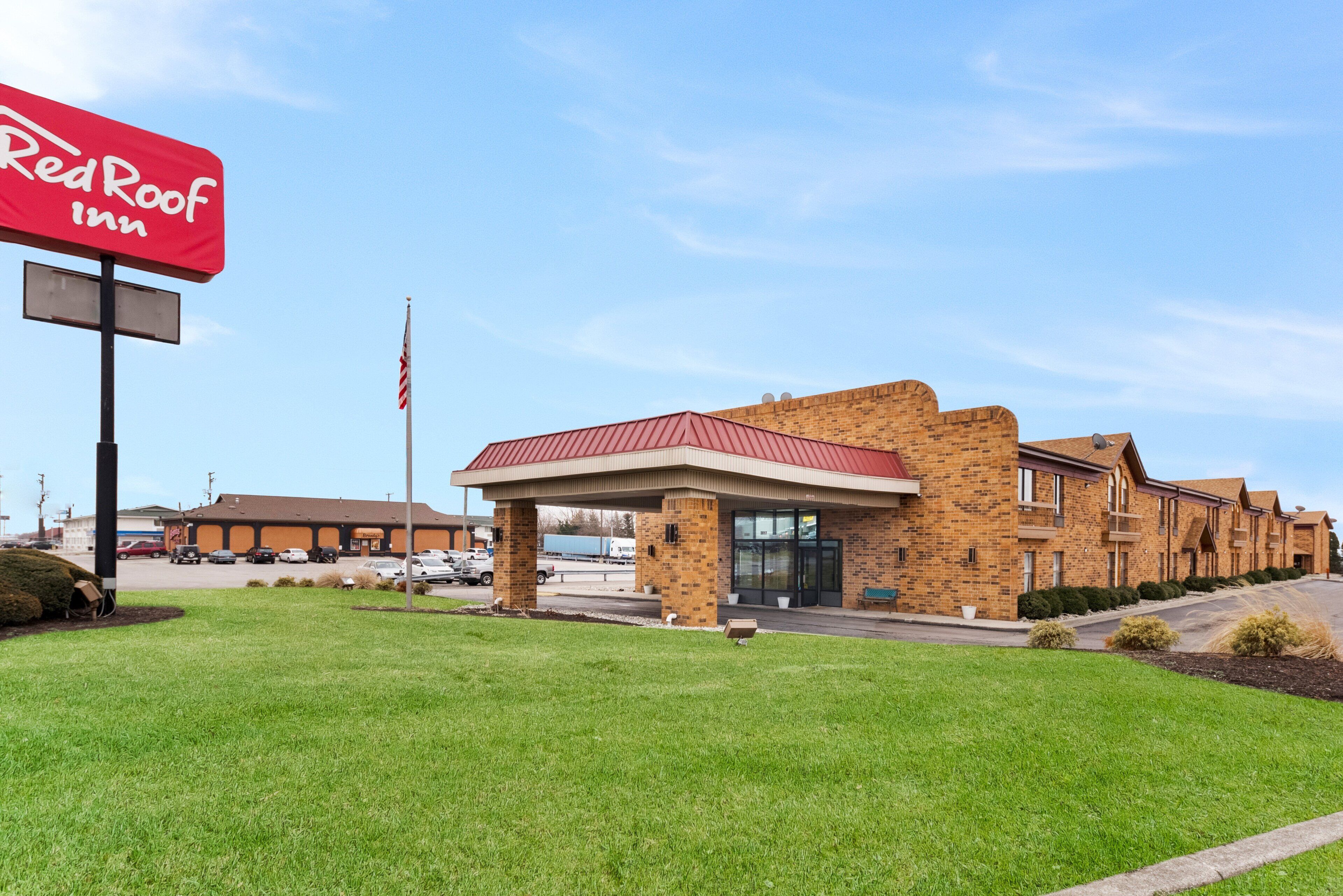 A Red Roof Inn with a brick facade, a covered entrance, and a parking lot.
