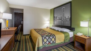 A hotel room with a bed, desk, chair, and a cityscape painting on the wall. - Super 8 by Wyndham College Park Wash DC Area (College Park)
