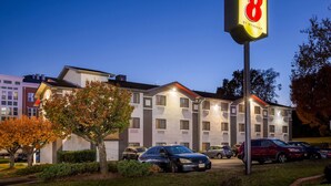 A hotel with a sign reading "Super 8 by Wyndham" in front of a building with multiple windows and a parking lot with several cars. - Super 8 by Wyndham College Park Wash DC Area (College Park)
