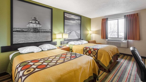 A hotel room with two beds, a large framed picture of a lighthouse, a window with curtains, and a striped rug. - Super 8 by Wyndham College Park Wash DC Area (College Park)