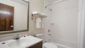 A bathroom with a white sink, a toilet, a bathtub, and a mirror. - Super 8 by Wyndham College Park Wash DC Area (College Park)