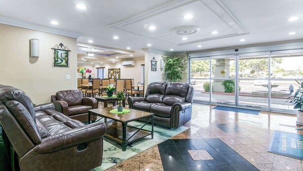 A lobby with leather sofas, a coffee table, and a reception desk. - Quality Inn & Suites (College Park)