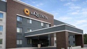 Ein La Quinta Hotel mit moderner Fassade, großen Fenstern und einer markanten Eingangshalle.