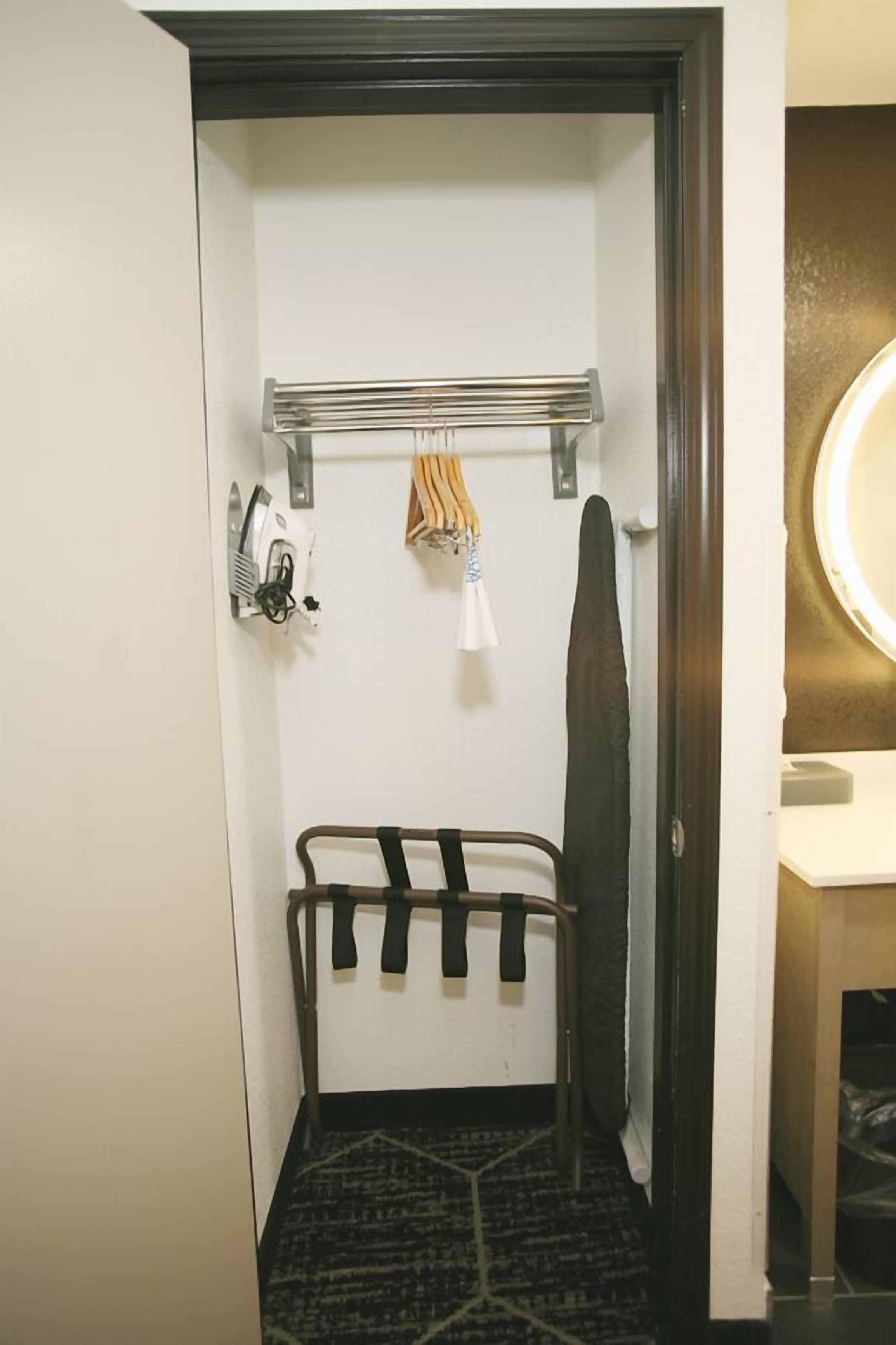 A compact bathroom with a towel rack, a hanging towel, a shower curtain rod, and a mirror.