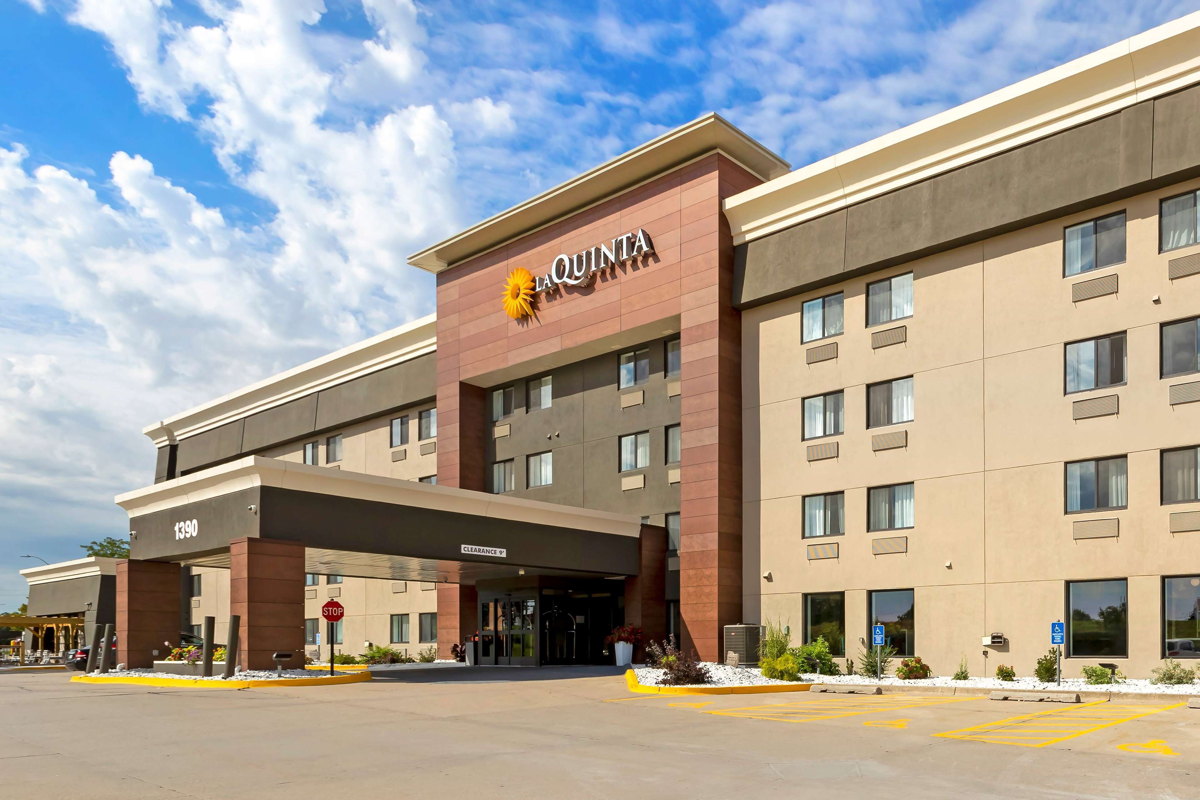 Un hotel amb una façana moderna, un senyal ben visible de 'La Quinta' i una entrada clara.