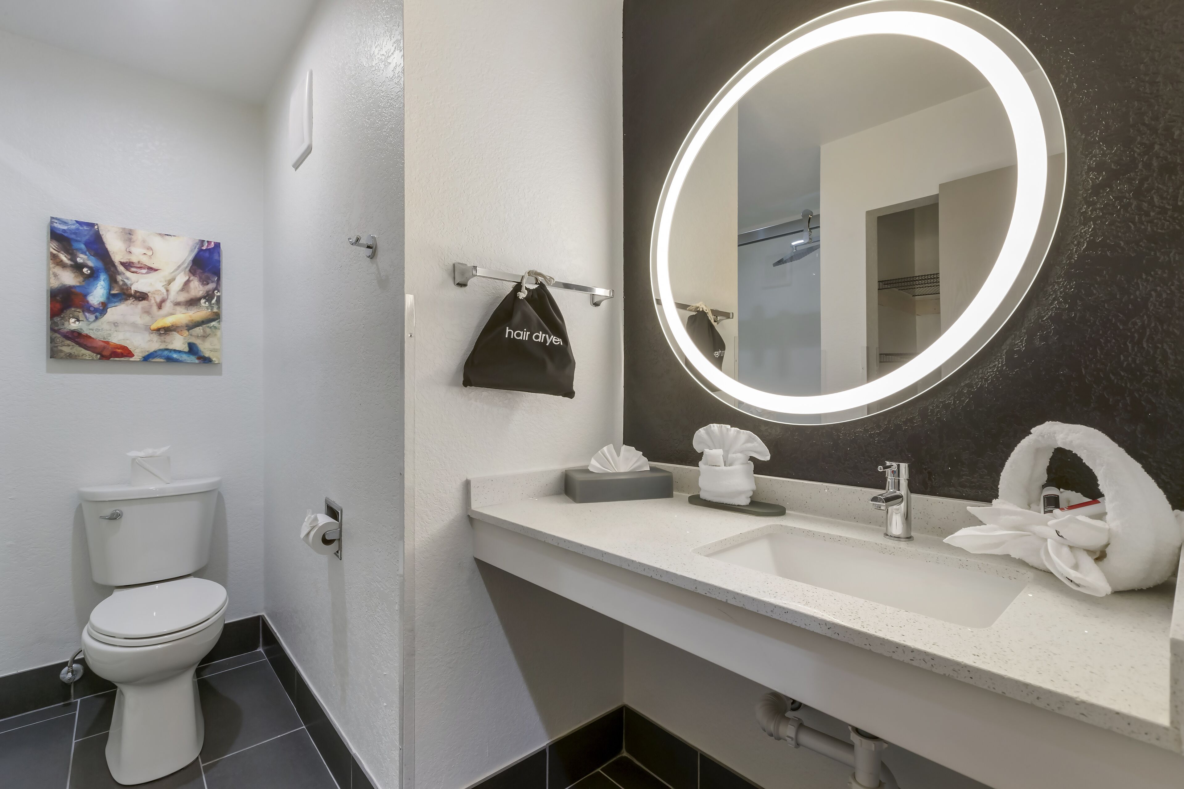 A modern bathroom with a toilet, sink, and mirror.