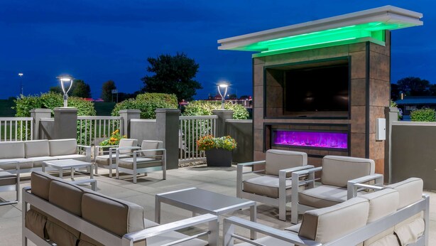 En udendørs terrasse med moderne møbler og en integreret pejs.