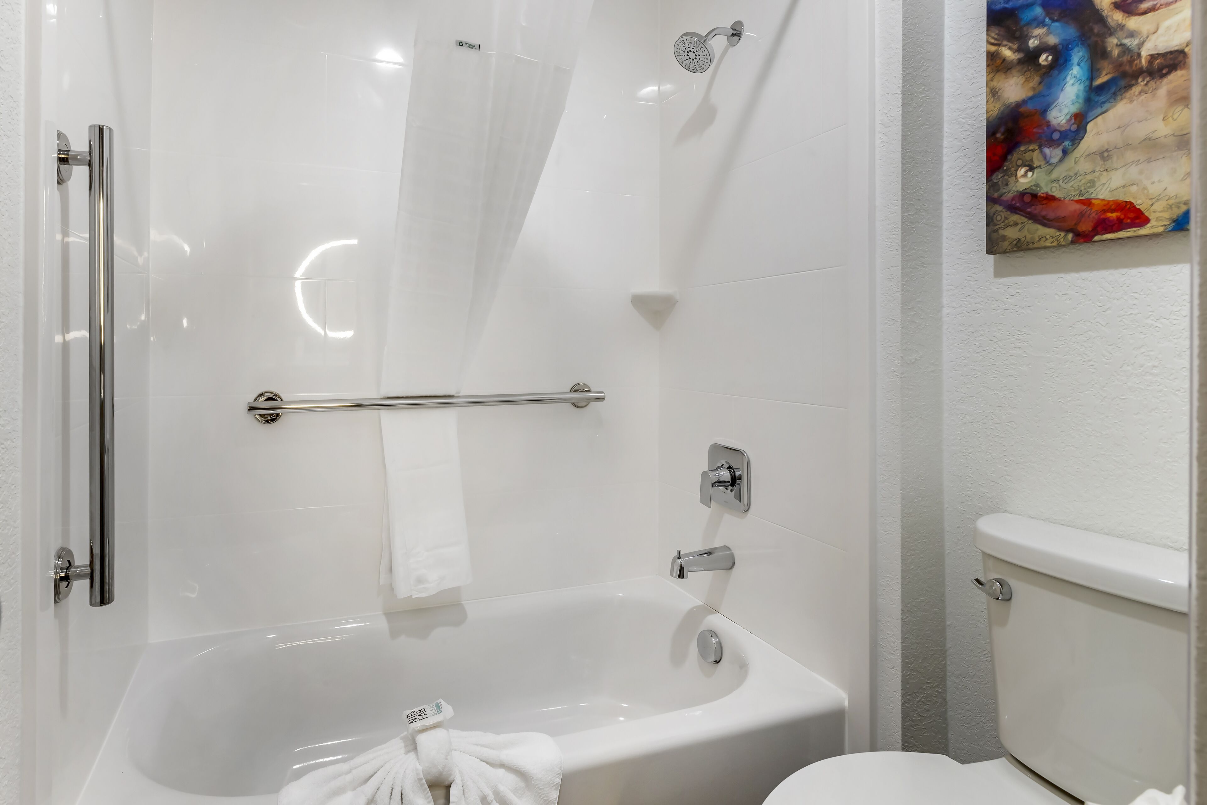 Un baño moderno con ducha envuelta en cristal, una bañera blanca y un inodoro.