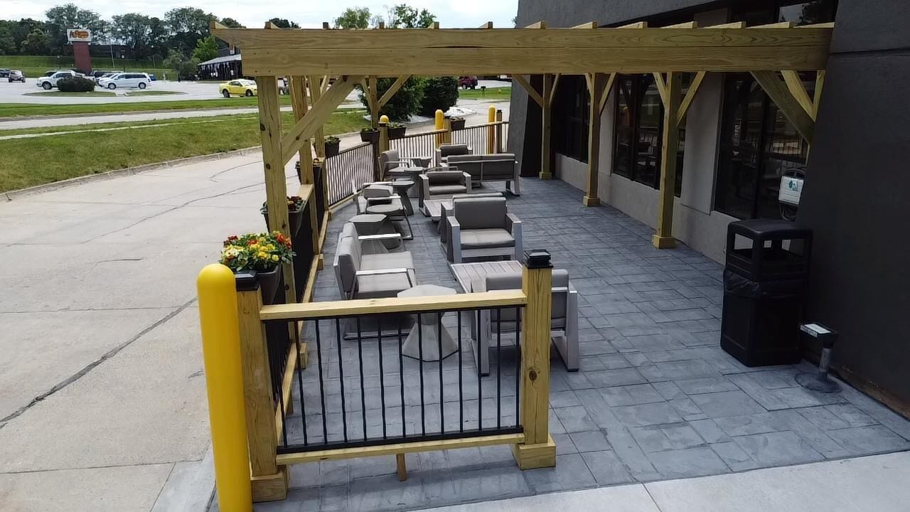 An outdoor patio area with seating and a wooden pergola.