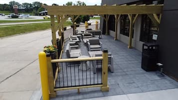 An outdoor patio area with seating and a wooden pergola.