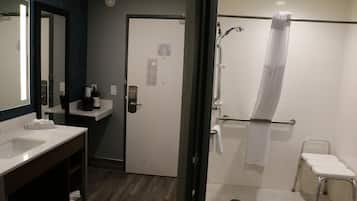 A modern bathroom with a shower, a sink, and a mirror.
