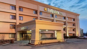 Un bâtiment de la chaîne La Quinta Inn & Suites, doté d’un design moderne, avec une entrée imposante et un parking.