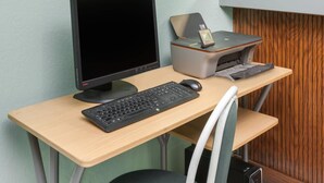 Ein Computertisch mit Bildschirm, Tastatur, Maus und Drucker.