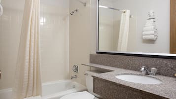 A bathroom with a bathtub, toilet, and sink.