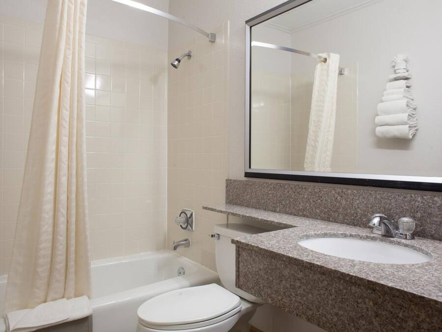A bathroom with a bathtub, toilet, and sink.