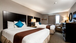 Une chambre d’hôtel avec deux lits, un bureau, une chaise, une machine à café et une télévision.