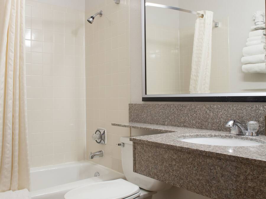 A bathroom with a toilet, sink, and shower.