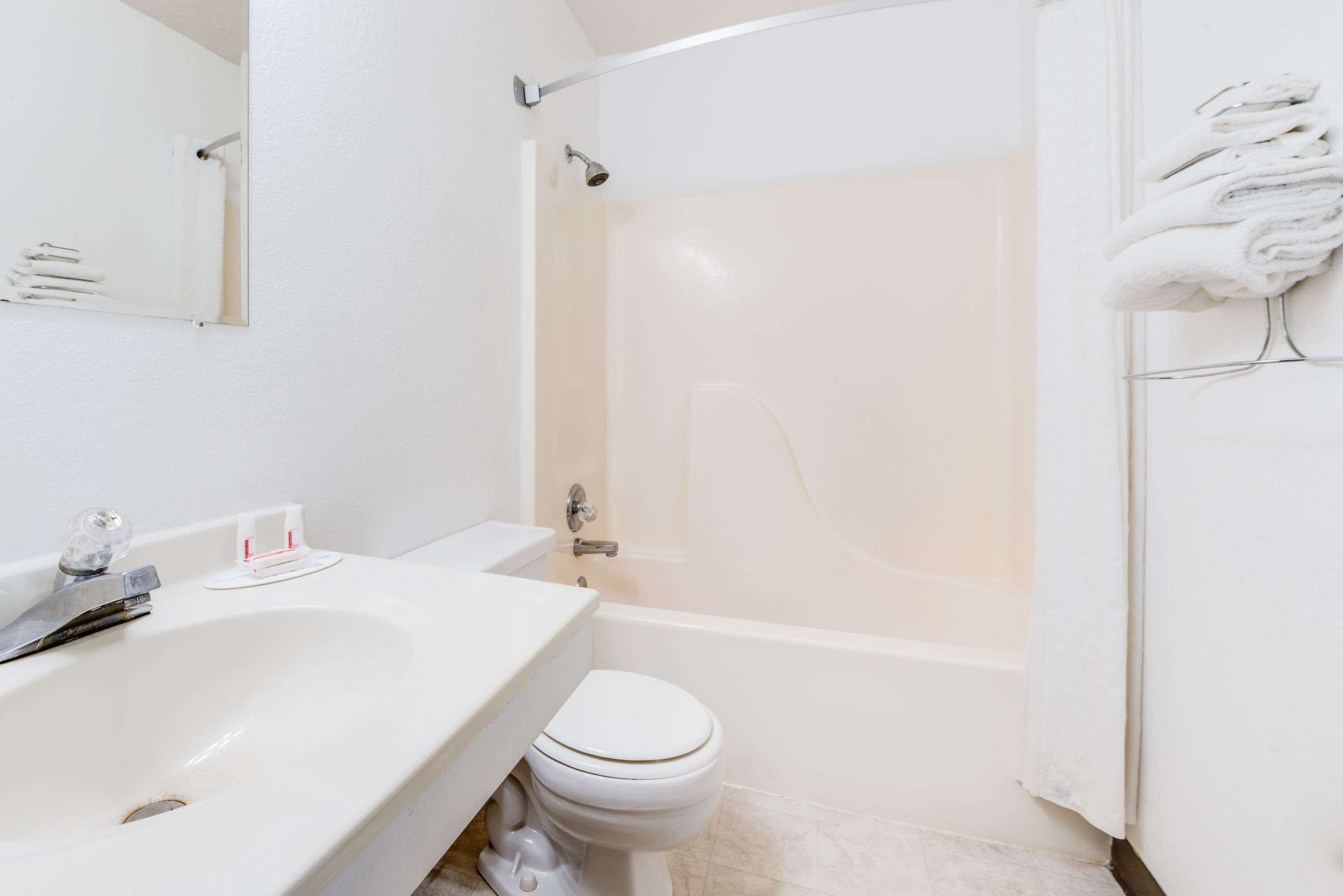 A bathroom with a white sink, toilet, and bathtub.