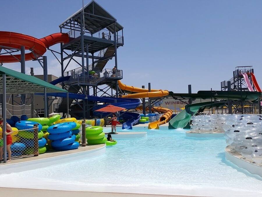 Un parco acquatico con diverse scivoli e gommoni gonfiabili.