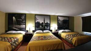 Habitación de hotel con dos camas individuales, cada una con una colcha estampada y almohadas blancas. Hay dos mesitas de noche con lámparas. Las paredes están decoradas con fotografías en blanco y negro de paisajes enmarcados.