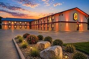 A Super 8 motel with a parking lot and landscaped garden. - Super 8 by Wyndham Champaign (Champaign)