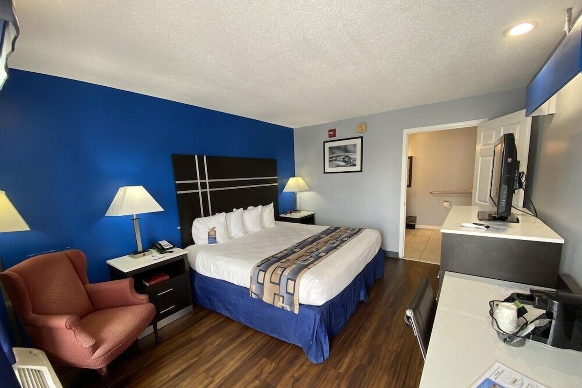 Une chambre d’hôtel comprenant un lit, un bureau, une chaise, une télévision et une salle de bain.