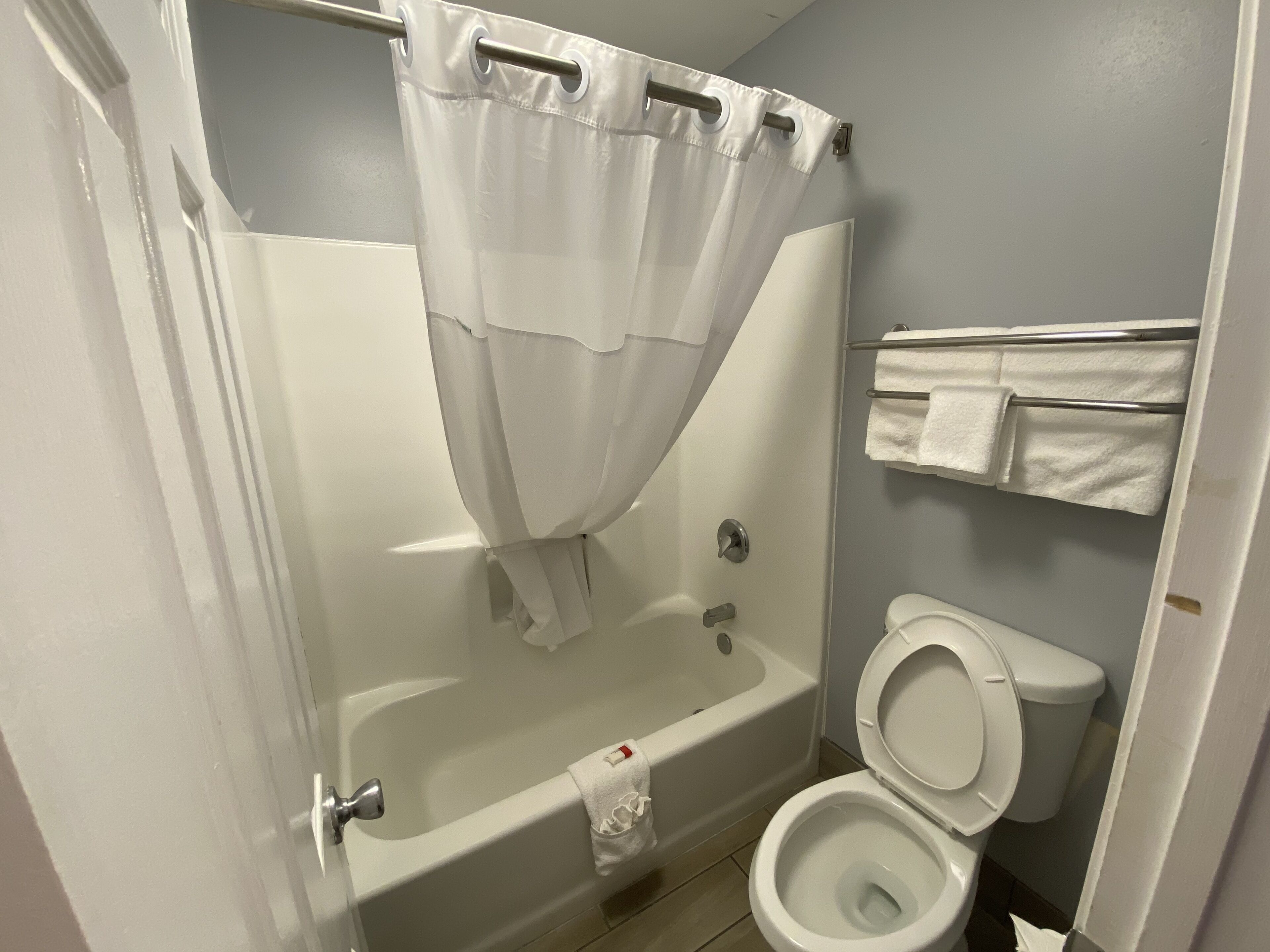 A bathroom with a bathtub, toilet, and a towel rack.