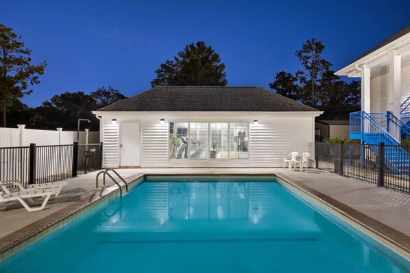 Una piscina al aire libre, sillones reclinables de piscina