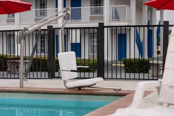 Una piscina al aire libre, sillones reclinables de piscina