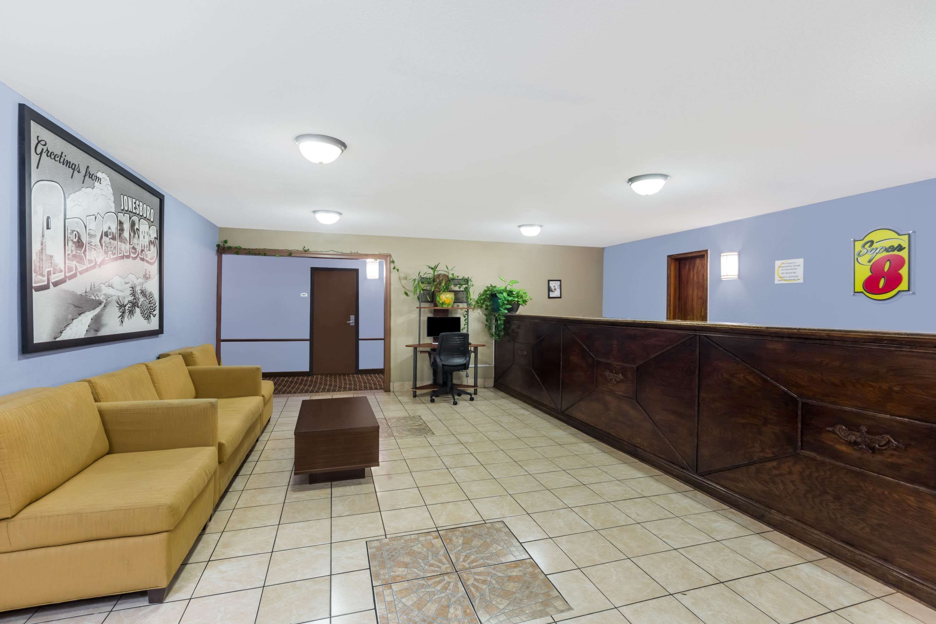 A reception area with a reception desk, a sofa, a coffee table, and a framed welcome sign.