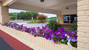 A covered outdoor area with a brick wall and flower beds. - FairBridge Inn Express Stuttgart (Stuttgart)