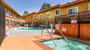 A hotel with a pool area, including a hot tub, lounge chairs, and a 'No Diving Allowed' sign. - Auburn House Hotel (Auburn)