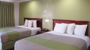 A hotel room with two beds, each with a wooden headboard, a green wall, and a green curtain. - Motel 6 Fresno, CA (Fresno)