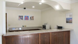 A kitchen with a wooden island, granite countertop, and a view of the dining area. - Motel 6 Fresno, CA (Fresno)