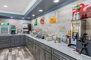 Une cuisine moderne équipée d’un espace dédié au café, d’un appareil à gaufres et d’un distributeur de jus.