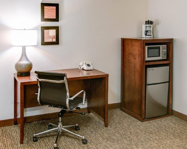 A hotel room with a wooden desk, a black office chair, a lamp, a telephone, a microwave, and a refrigerator. - Comfort Inn Redding Near I-5 (Redding)