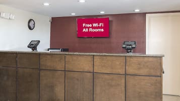 A reception desk with a sign indicating free Wi-Fi in all rooms.