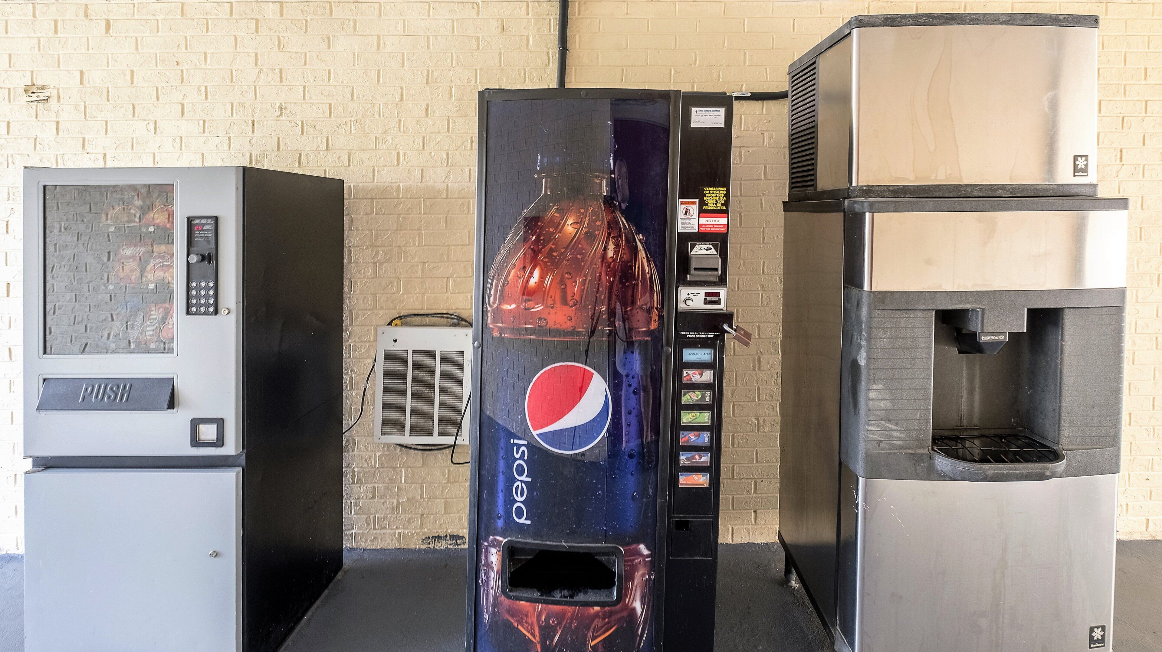 Una máquina expendedora con el logotipo de Pepsi, un botón pulsador y una ranura para monedas.