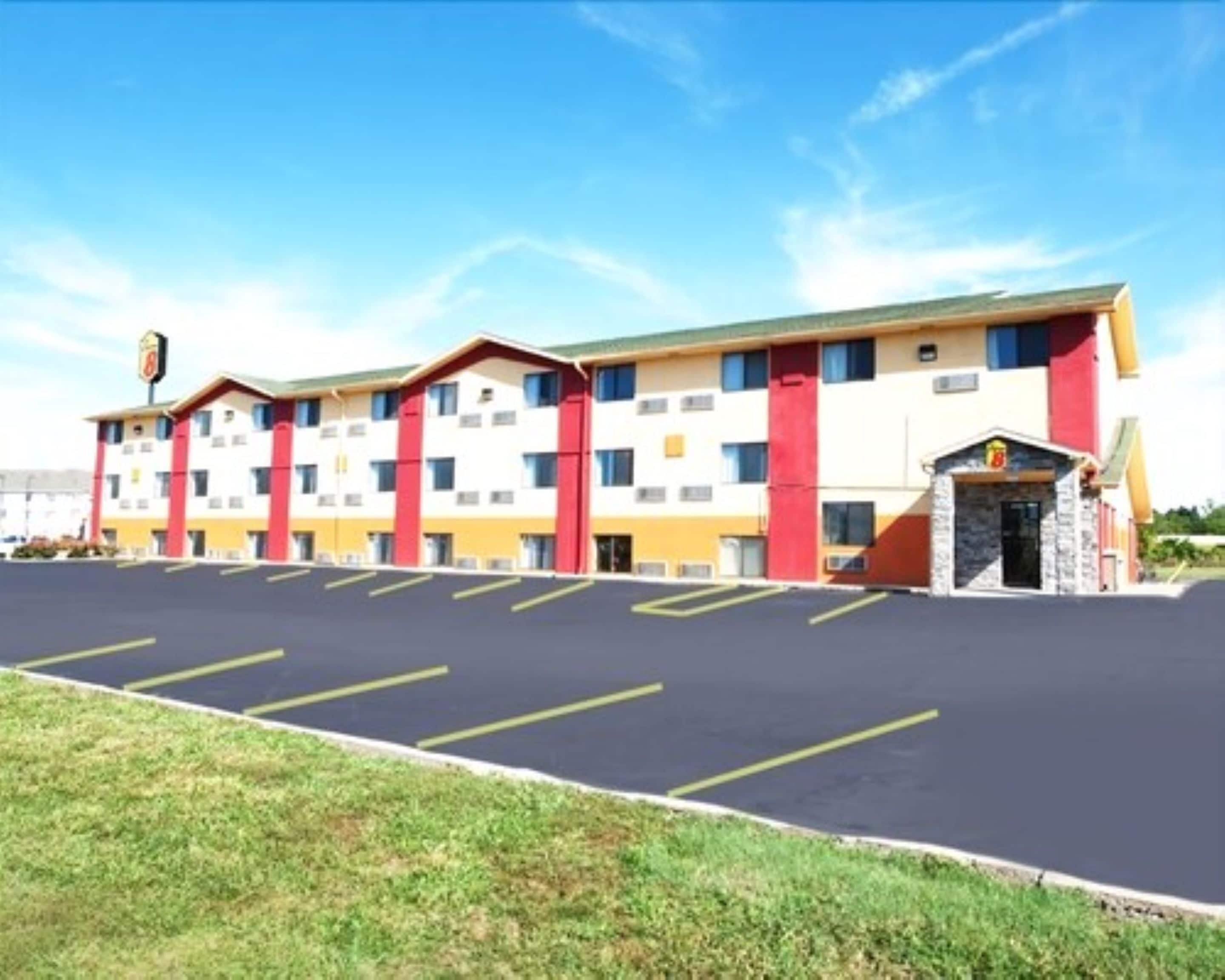 A multi-story hotel with a parking lot in front.