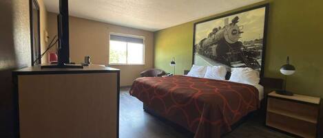 A bedroom with a bed, a television, a window, a painting, and a nightstand.