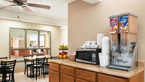 A hotel kitchen with a coffee station, a microwave, and a fruit bowl. - Super 8 by Wyndham Liberal KS (Liberal)