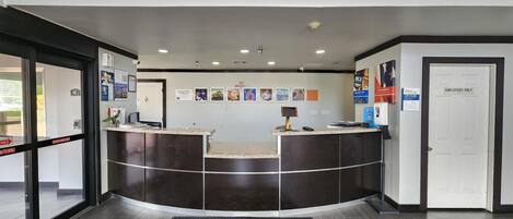 A reception area with a curved counter, a security camera, and a 'No Vacancy' sign.