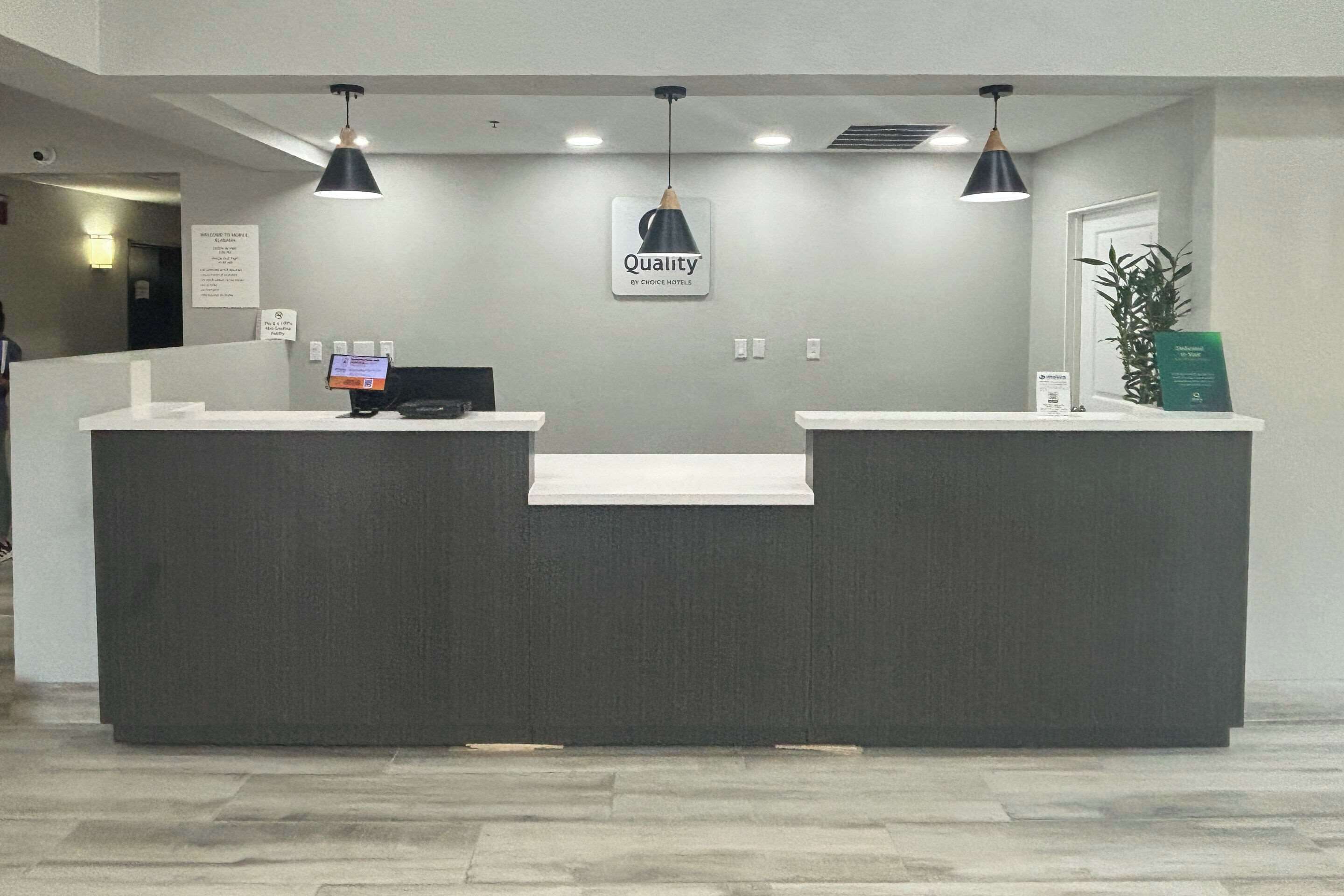 A reception desk with a sign reading "Quality by Choice Hotels."