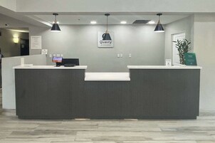 Un mostrador de recepción con un cartel que dice 'Quality by Choice Hotels'.