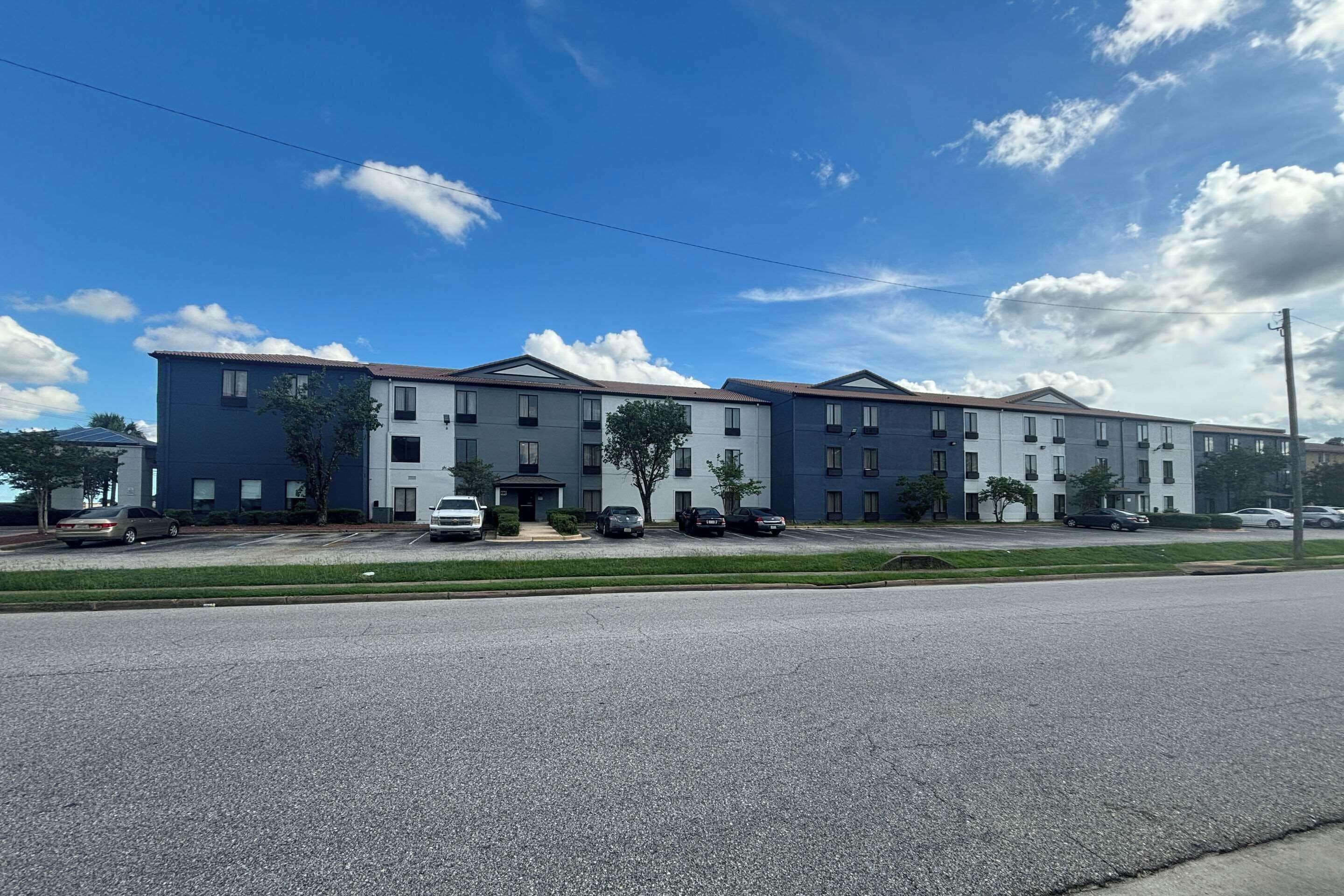 A multi-story building with a row of windows and a flat roof.