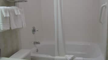 A bathroom with a bathtub, a toilet, and a sink. There are towels on the wall and a shower curtain.