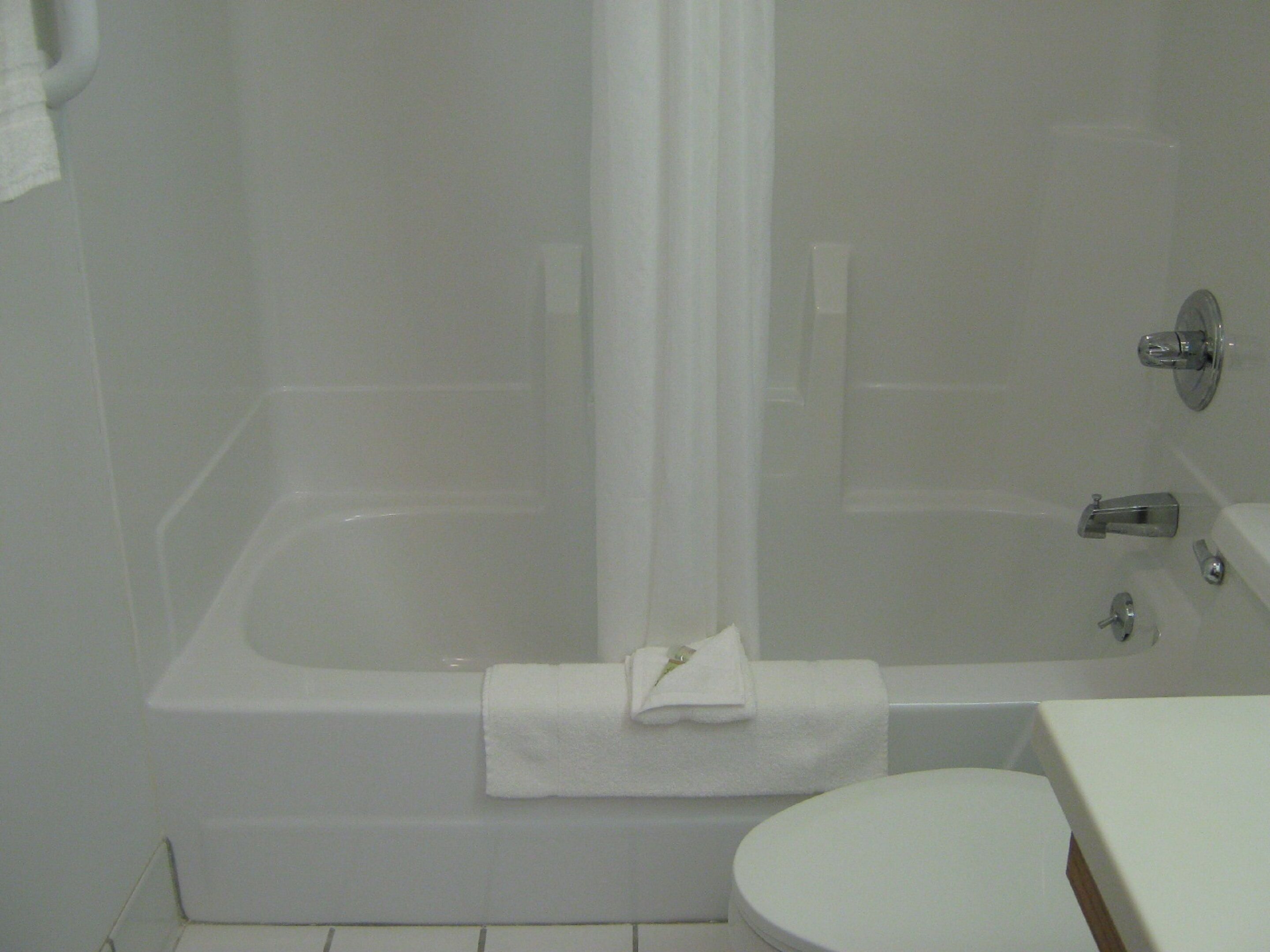 Ein Badezimmer mit Badewanne, Toilette und Duschvorhang.