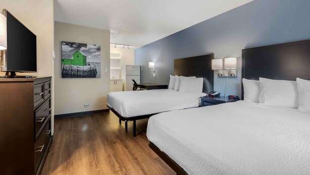 A hotel room with two beds, a TV, a desk, and a refrigerator. - Extended Stay America Suites Dallas Coit Road (Dallas)