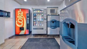 A vending machine area with a Coca-Cola machine, a water dispenser, and a microwave.